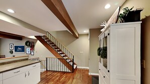 Une cuisine moderne avec un plancher en bois, un comptoir intégré et un escalier menant à un autre niveau.