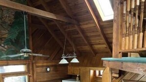 Ein gemütliches Blockhaus-Interieur mit Essbereich, Küche und einer Couch.