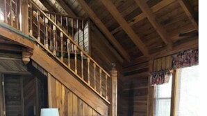 Ein Holzblockhaus-Interieur mit einer Couch, einem Sessel und einem Couchtisch.