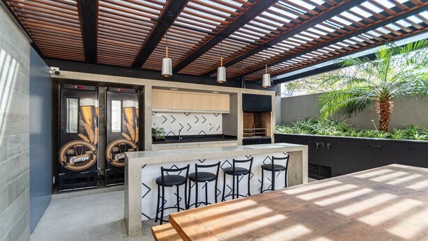 A modern outdoor kitchen area with a bar and seating. - Stylish & Charming in Consolação/Higienópolis • Parking • 3rd Guest Free (Sao Paulo)