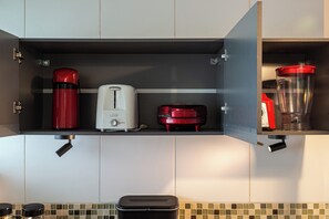 A kitchen with a built-in shelf containing a red coffee maker, a white toaster, and a red blender. - Stylish & Charming in Consolação/Higienópolis • Parking • 3rd Guest Free (Sao Paulo)