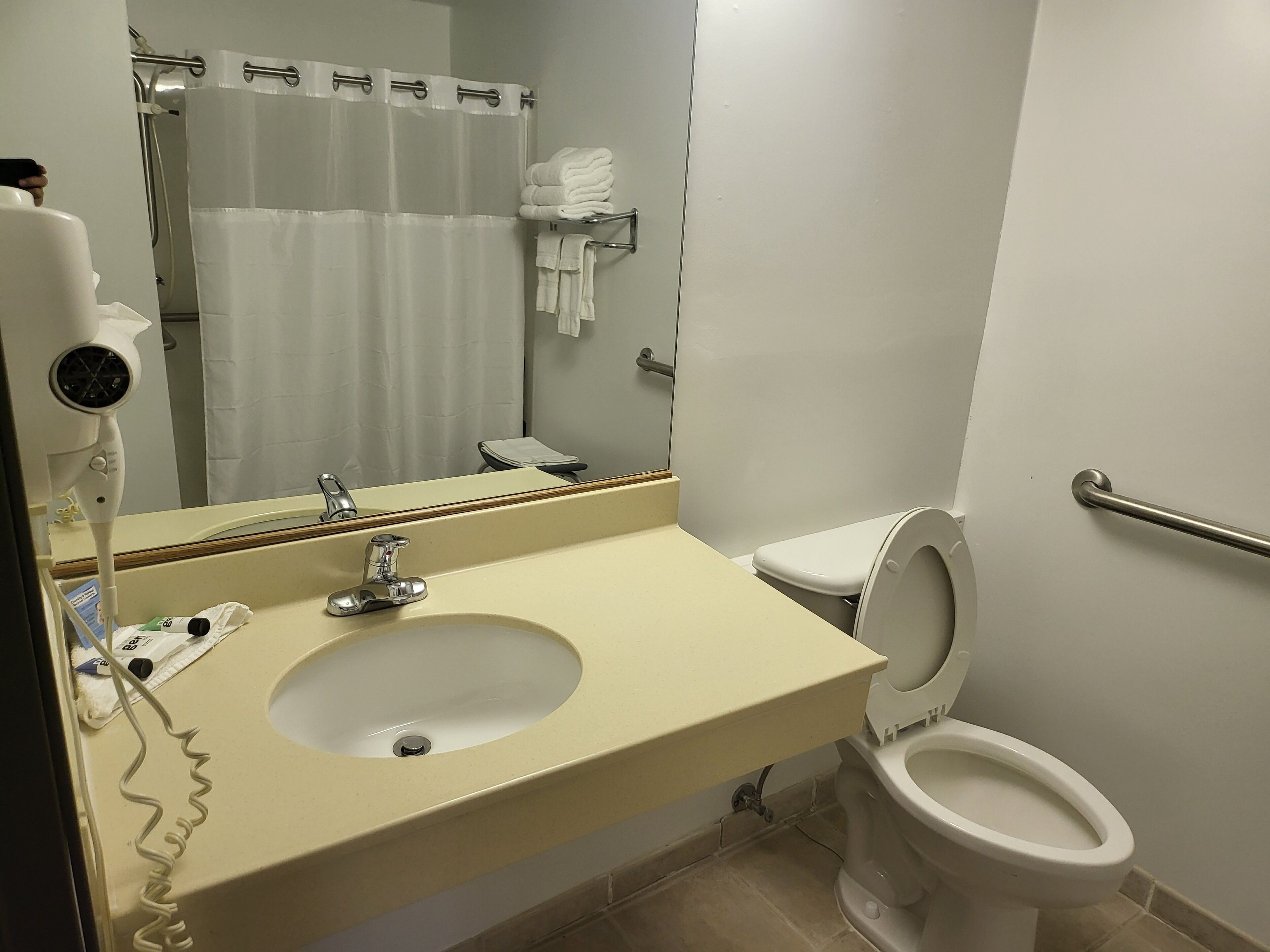 A bathroom with a sink, toilet, and shower curtain.