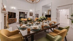 A dining room with a large table set for a meal, surrounded by chairs. - Luxury London 3-Bedroom Duplex with Pool Table (Greater London)