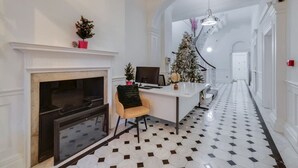 A hallway with a fireplace, a desk with a computer, and a Christmas tree. - Modern Elegance: 1-Bedroom City Living in London (Greater London)