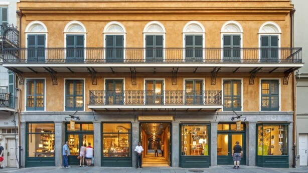 Un edificio a due piani, con un negozio al piano terra e balconi al piano superiore.