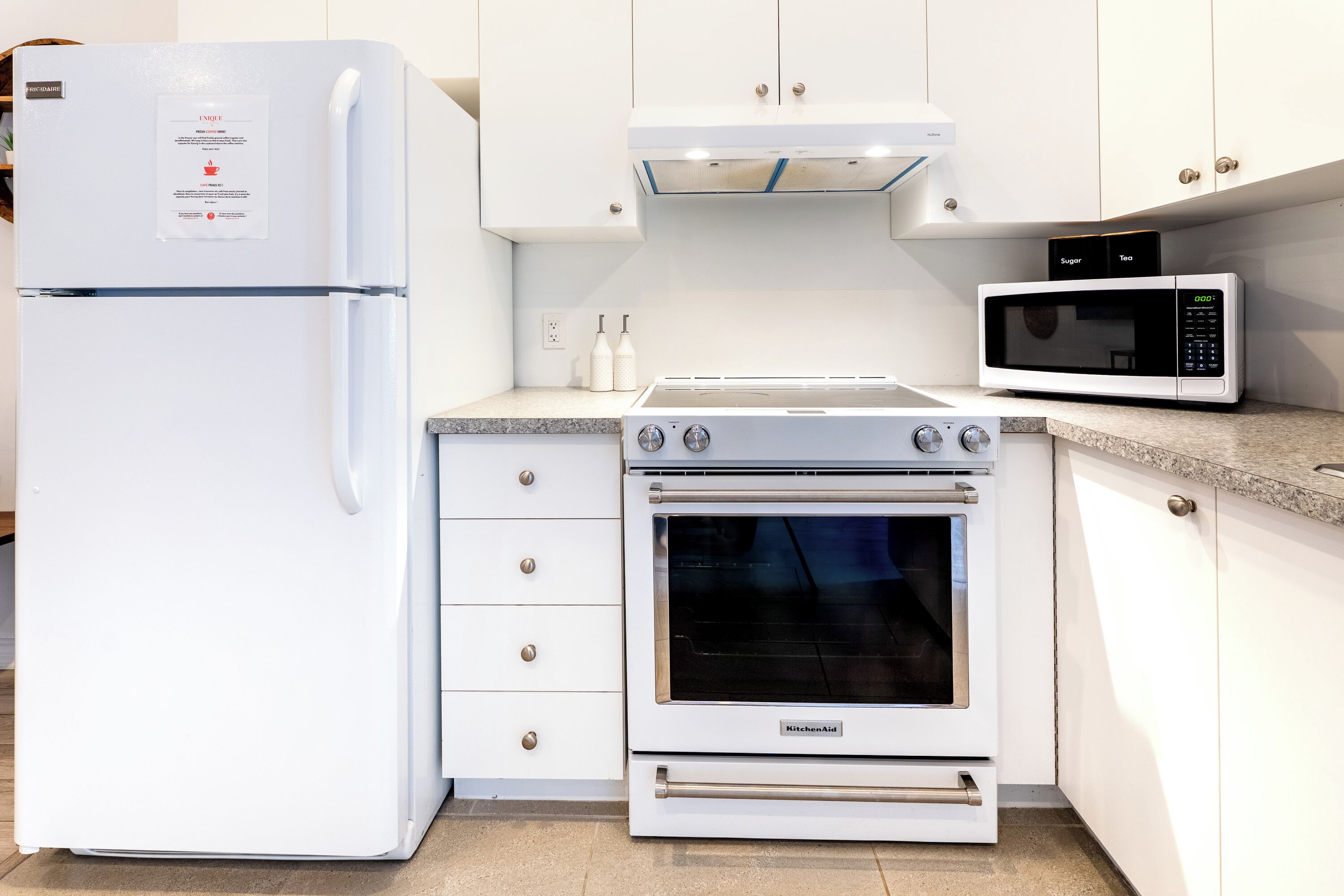 A kitchen with a white refrigerator, a microwave, and an oven.