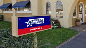 Americas Best Value Inn -hotellin kyltti, jossa on myös sisäänkäynnin opastekyltti.