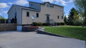 A two-story building with a flat roof, a satellite dish, and a small front porch.