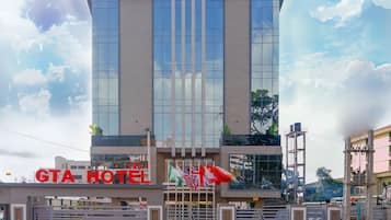 A modern hotel building with a prominent sign reading "GTA HOTEL".