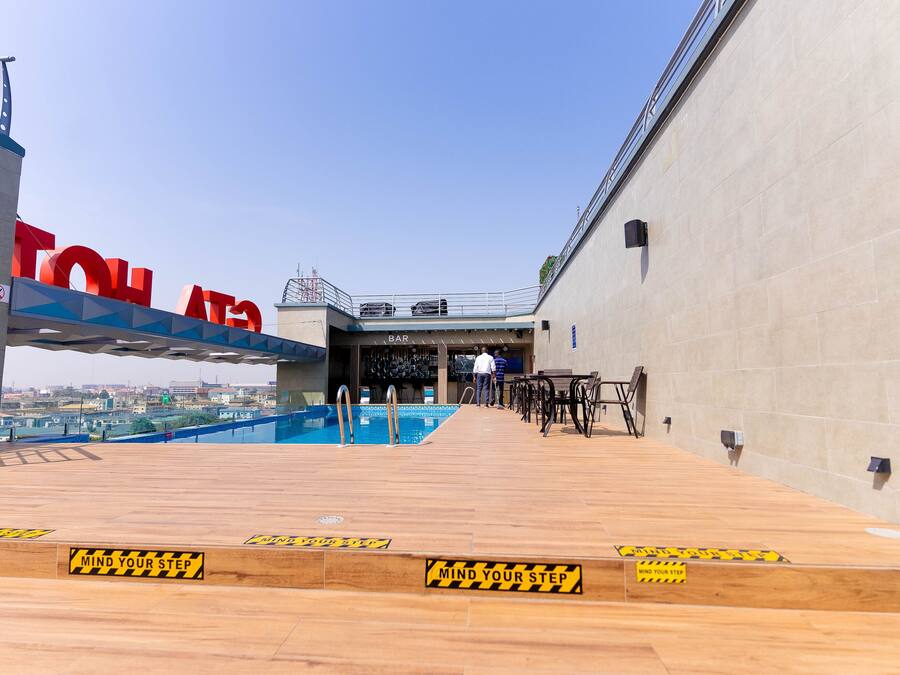 Un bar situé sur le toit, avec une piscine, un espace bar et des sièges en plein air.