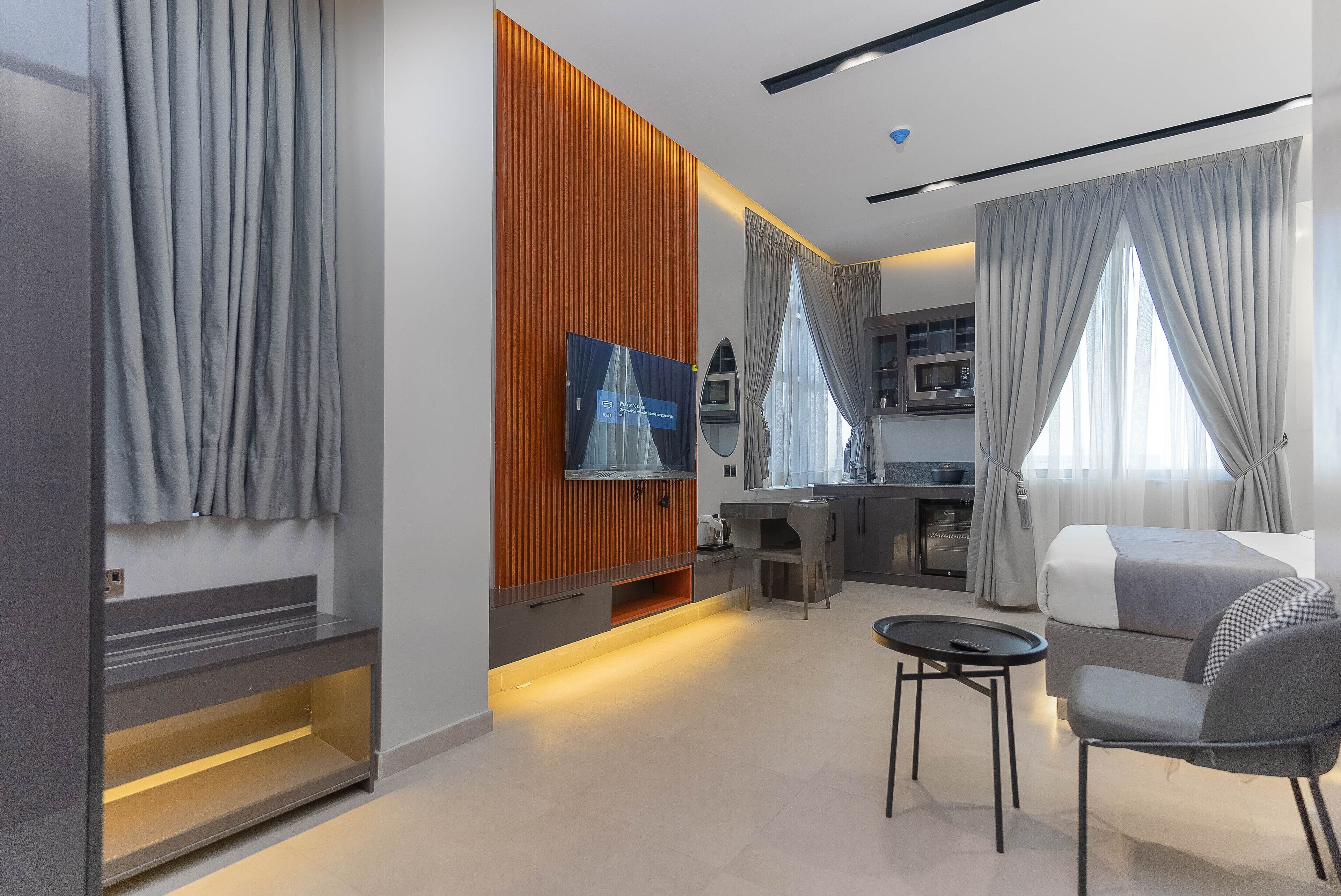 A modern living room with a TV, sofa, and dining area.