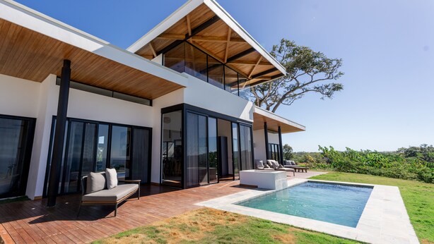 A modern house with a large deck, a swimming pool, and a view of the surrounding landscape. - Oceanvista Villa I Santa Teresa Beach  Brand New Oceanview Villa Gated Community (santa teresa)