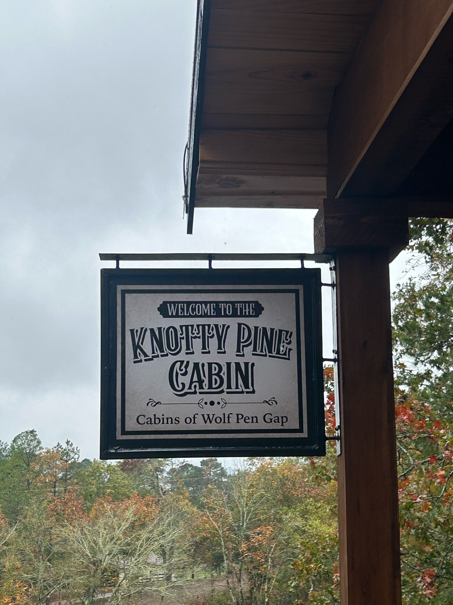 A sign for the Knottly Pine Cabin, indicating it is part of the Cabins of Wolf Pen Gap.