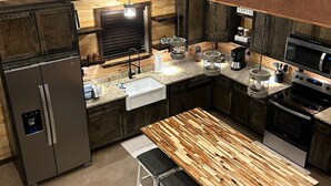 Una cocina moderna con armarios de madera, electrodomésticos de acero inoxidable y una isla central con asientos.
