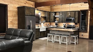 Una cocina moderna con muebles de madera, un refrigerador, un microondas y una estación para café.