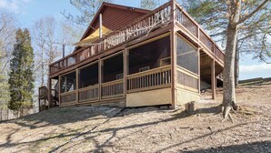 A wooden cabin with a balcony, large windows, and a covered porch area. - Welcome to “Relaxing on the Cumberland” – Your Perfect Cozy Escape (Burnside)