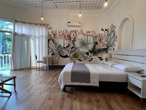 A bedroom with a large bed, a desk, a chair, and a mural on the wall. - HOTEL PERLA CENTRAL MALECON (Guayaquil)