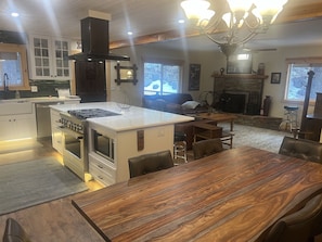 Una cocina moderna con una isla central, horno integrado y un amplio comedor.