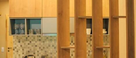 A modern kitchen with wooden cabinets, a tiled backsplash, and a coffee maker on the counter.