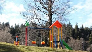 Un'area giochi con altalene, uno scivolo e una struttura per arrampicata.