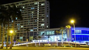 Ein mehrstöckiges Hotel mit modernem Design, das durch ein markantes Gebäude mit vielen Fenstern und einer gut beleuchteten Fassade gekennzeichnet ist.