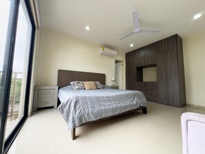 Une chambre à coucher comprenant un lit, une armoire, un ventilateur de plafond et un appareil de climatisation.