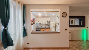 A modern kitchen with a central island, white cabinets, and a clock on the wall.