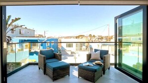 Ein Balkon mit Korbmöbeln und Blick auf die Stadt.