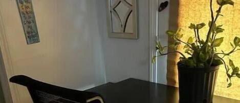 Un piccolo ufficio con scrivania, sedia e una pianta in vaso.