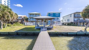 A waterfront promenade with a gazebo, a small bridge, and buildings with balconies. - Amazing New Lagoon View Home (Gulf Shores)