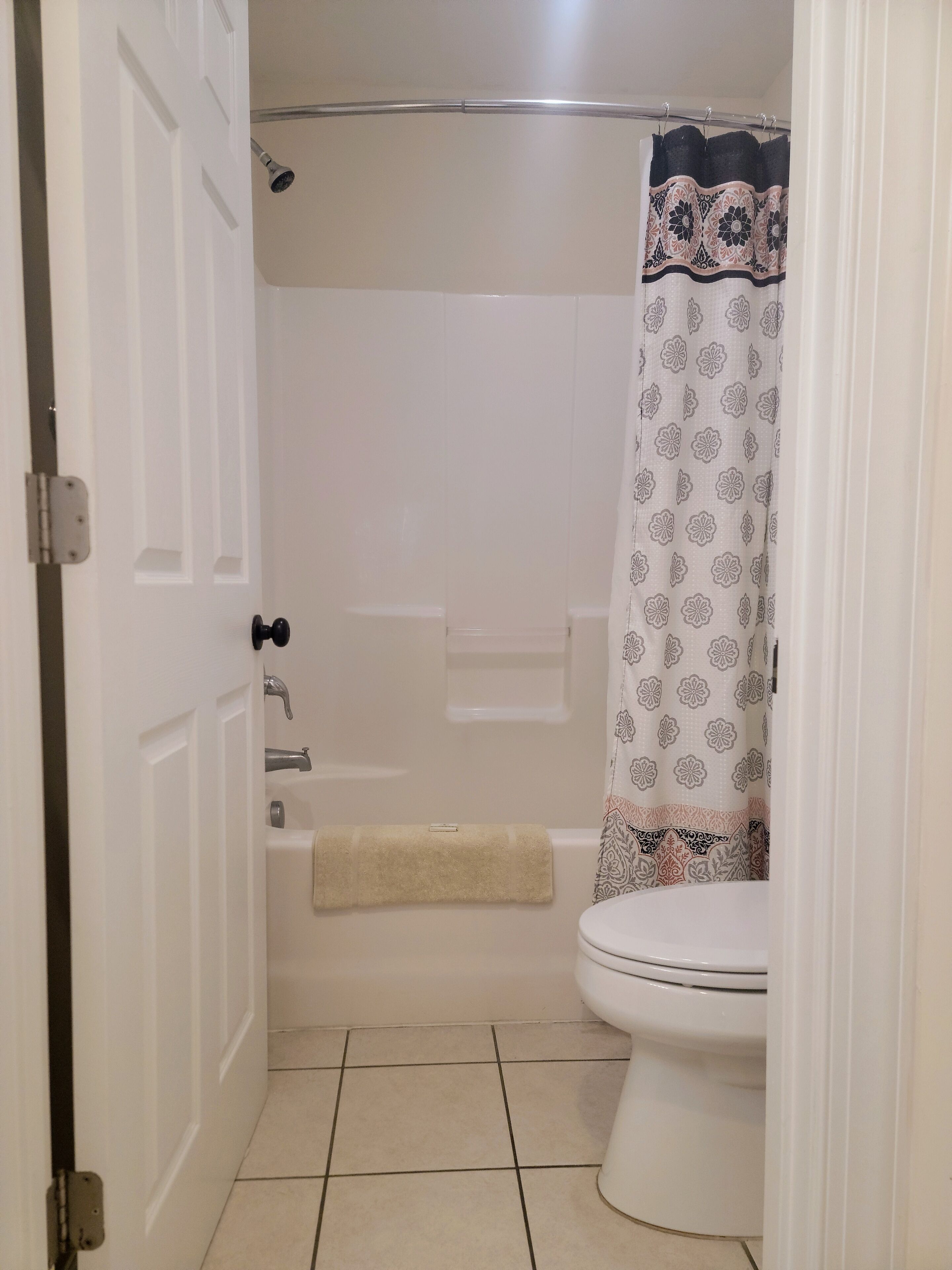 Un baño con inodoro, bañera y cortina de ducha.