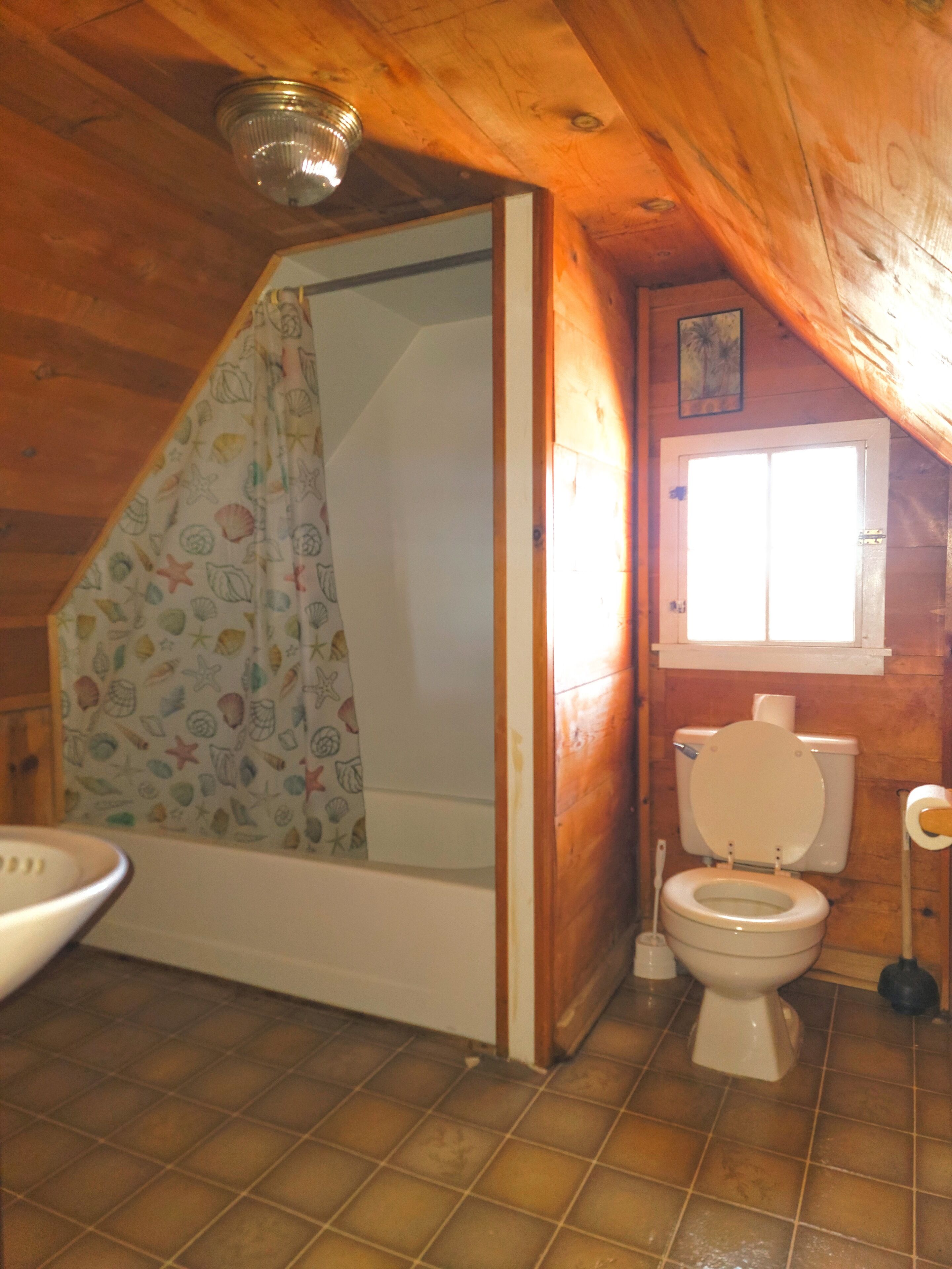 A bathroom with a shower, toilet, and sink.