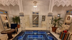 A luxurious pool area with intricate tile work and a central star design. - Riad Explore (Marrakech)