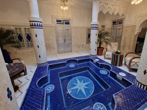 A courtyard with a tiled swimming pool featuring geometric patterns and star designs. - Riad Explore (Marrakech)