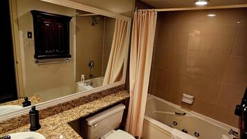 Une salle de bain équipée d’un lavabo, de toilettes, d’une baignoire et d’un rideau de douche.