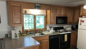 A kitchen with wooden cabinets, a microwave, a dishwasher, and a coffee maker.