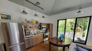Een moderne keuken met roestvrijstalen apparatuur, houten kasten en een eethoek met een tafel en stoelen.