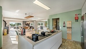 A modern kitchen with a central island, a dining area with a view, and a living space with a fireplace.