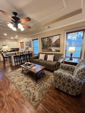 A living room with a sofa, armchair, coffee table, and a dining area with chairs and a table. - Get to BLUES-in' at Rusty's Roost, adjacent to downtown Clarksdale, MS (Clarksdale)