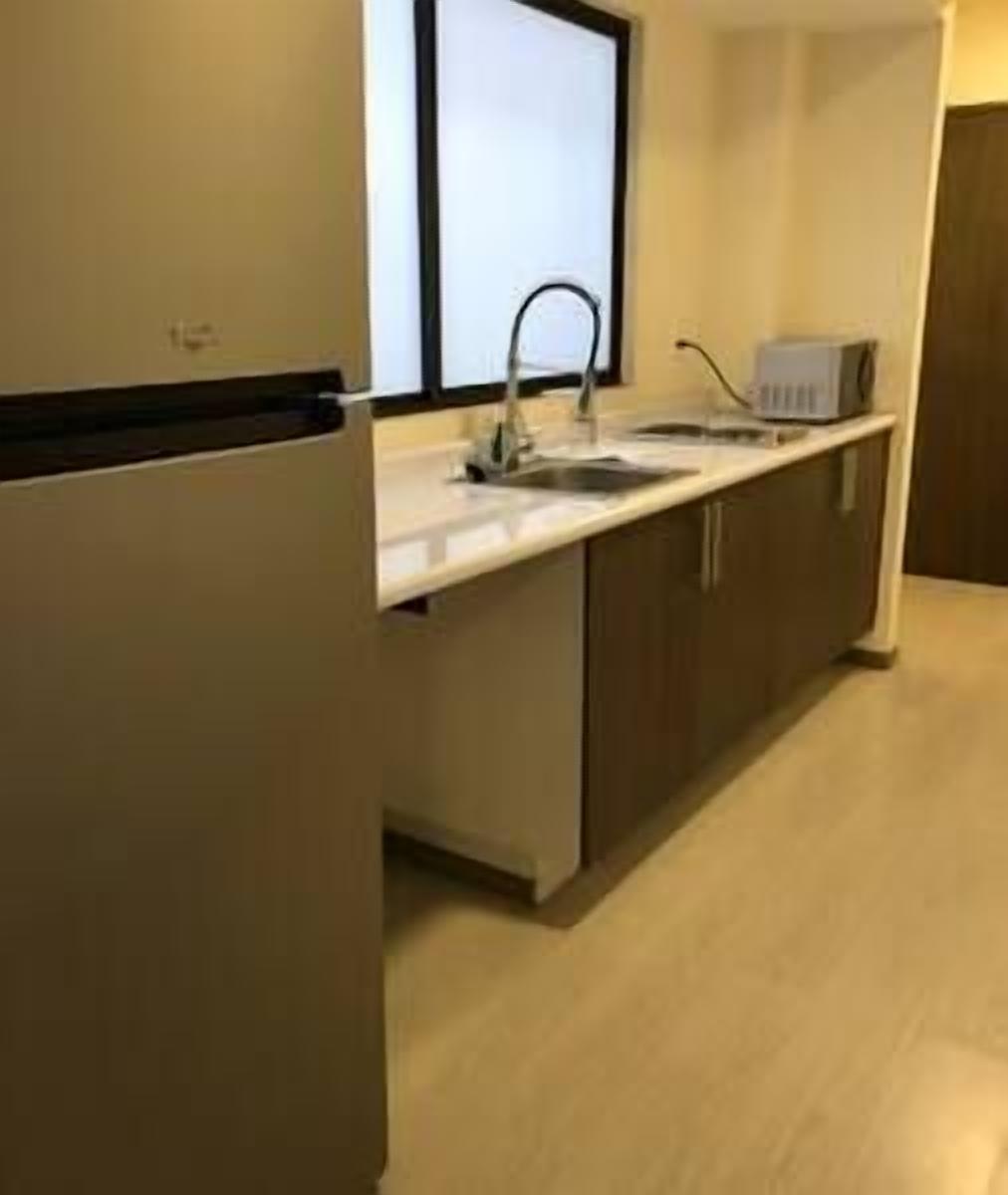 Una cocina moderna con horno empotrado, un lavabo y un microondas.