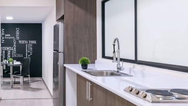 A modern kitchen with a large island, stainless steel appliances, and a minimalist design. - New and excellent conditions (Benito Juárez)