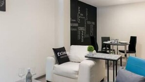 A modern living room with a white sofa, a small table with a plant, and a dining area with a table and chairs. - New and excellent conditions (Benito Juárez)