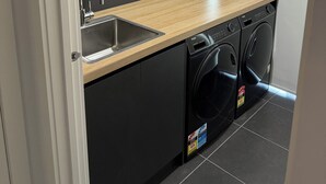 A compact kitchen with a built-in dishwasher, a sink, and wooden cabinets.