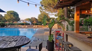 A poolside area with lounge chairs, a wooden table, and a bar area with a menu board. - Nice T4 appartement in Hotel Residence at Lecci near Cala Rossa Beach (Lecci)