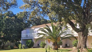 A two-story building with a balcony, surrounded by trees and a well-maintained lawn. - Nice T4 appartement in Hotel Residence at Lecci near Cala Rossa Beach (Lecci)
