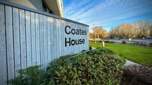 A sign for Coates House with a modern building facade and a landscaped garden area. - Coates House by Guestz (Bristol)