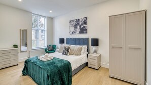 A bedroom with a bed, bedside tables, a wardrobe, a window, and a mirror. - Eden Grove 2 Bed Holiday Retreat With Hottub (Bolton)