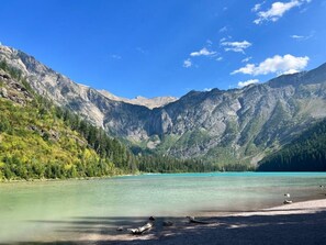 A mountain landscape with a clear lake and forested hills.