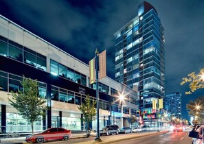 A modern building with large windows and a flagpole. - Urbanest - Spectacular Views & Amenities Downtown (Calgary)
