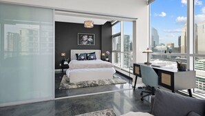 Une chambre moderne avec un grand lit, un bureau et une vue sur la ville.